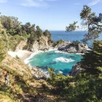 Randonneur admirant les falaises blanches et les eaux turquoise des Calanques.
