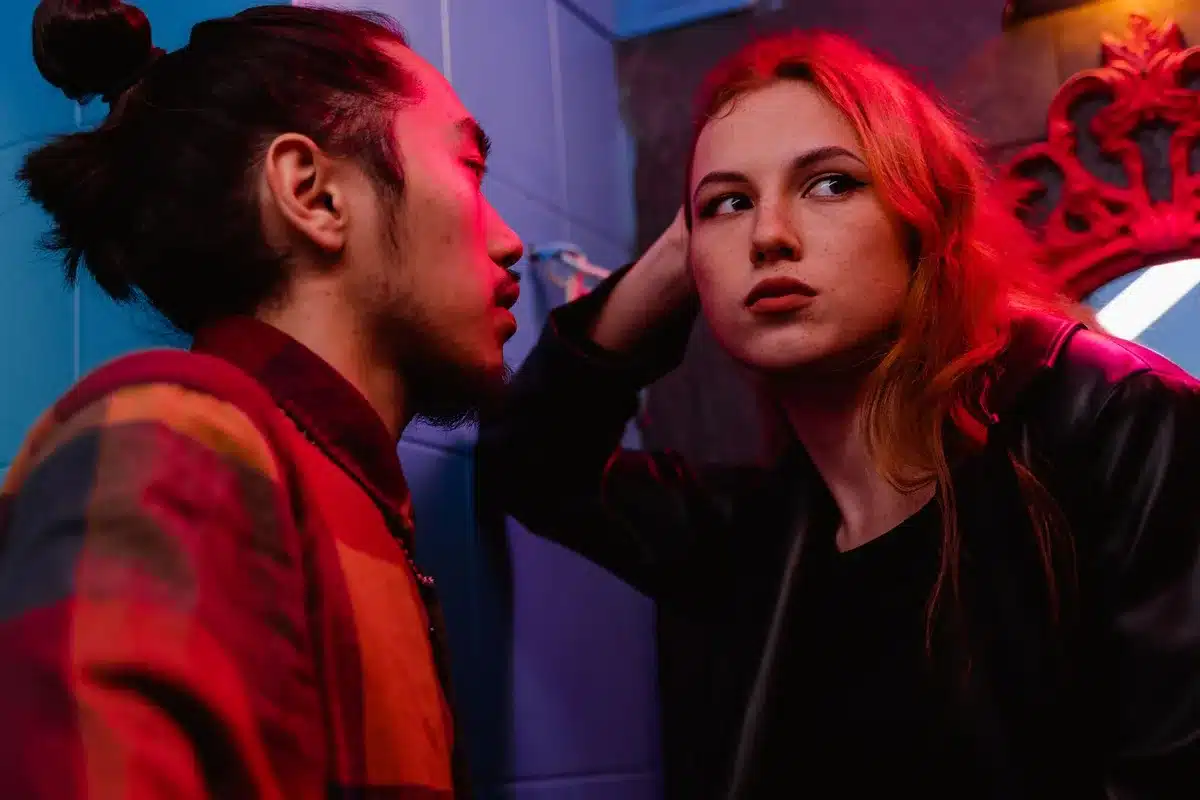Deux jeunes gens se parlent dans un bar mal éclairé, ambiance musicale et chaleureuse