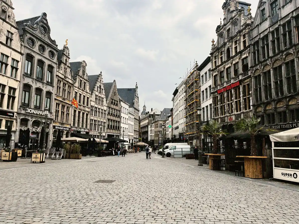 Voyageur à pied dans une place historique européenne avec architecture médiévale et cafés