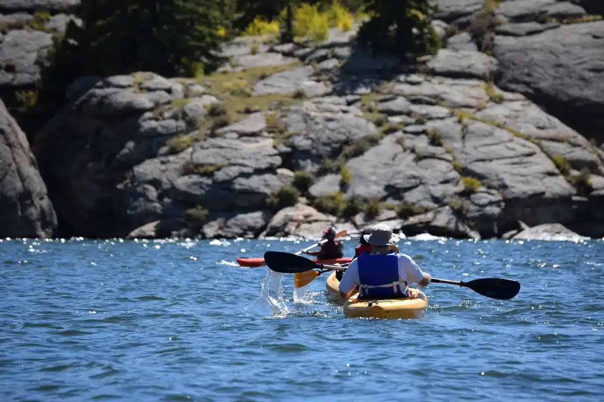 Personnes pratiquant le paddle et les sports nautiques sur un lac en été