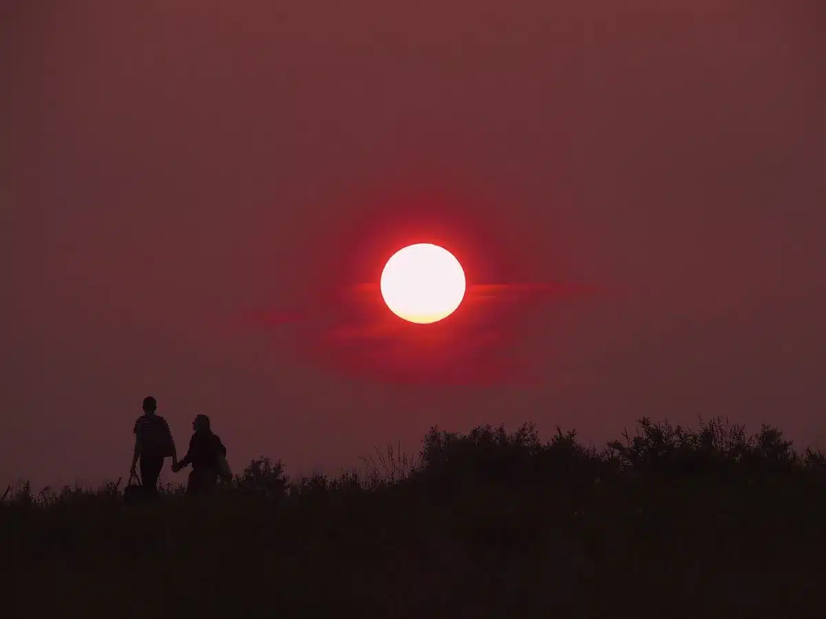 Deux femmes marchant côte à côte sur une plage hivernale brumeuse, en conversation intime