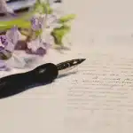 Main anonyme feuilletant un manuscrit sur une table d'écrivain bien éclairée