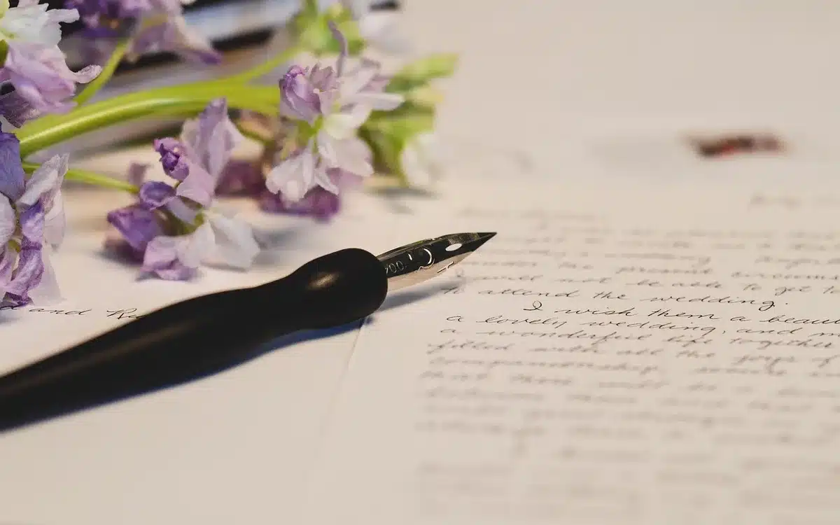 Main anonyme feuilletant un manuscrit sur une table d'écrivain bien éclairée