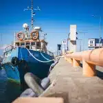 Famille anonyme montant à bord d'un voilier amarré en marina