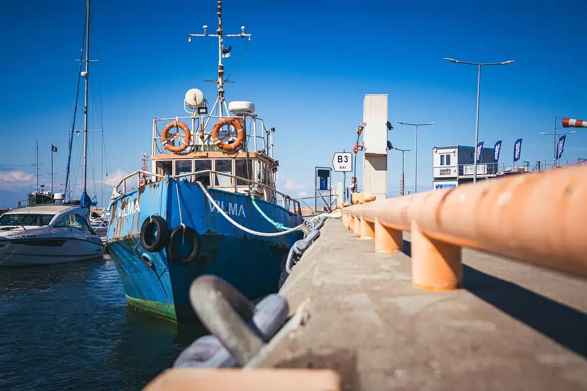 Famille anonyme montant à bord d'un voilier amarré en marina